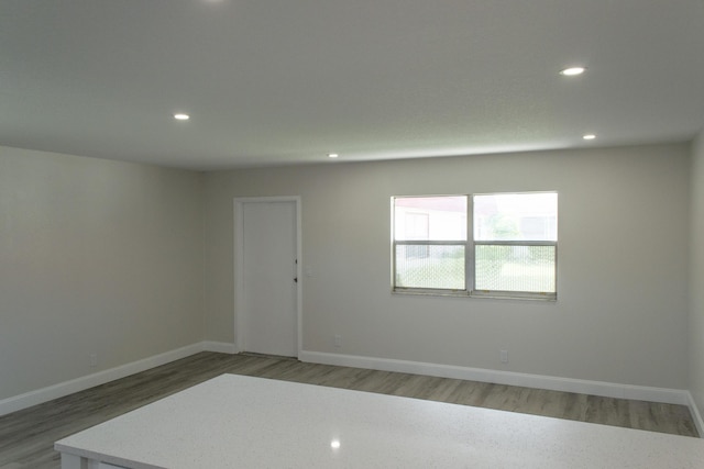 spare room featuring baseboards, light wood-style floors, and recessed lighting