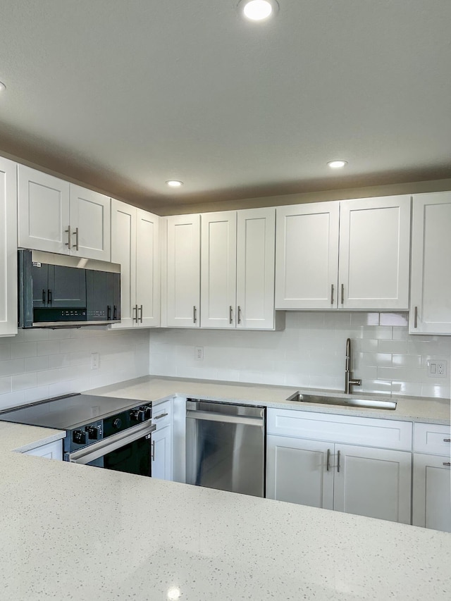 kitchen with white cabinets, tasteful backsplash, stainless steel appliances, and a sink