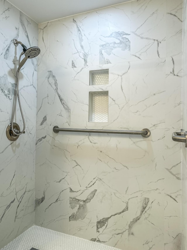 bathroom featuring a marble finish shower