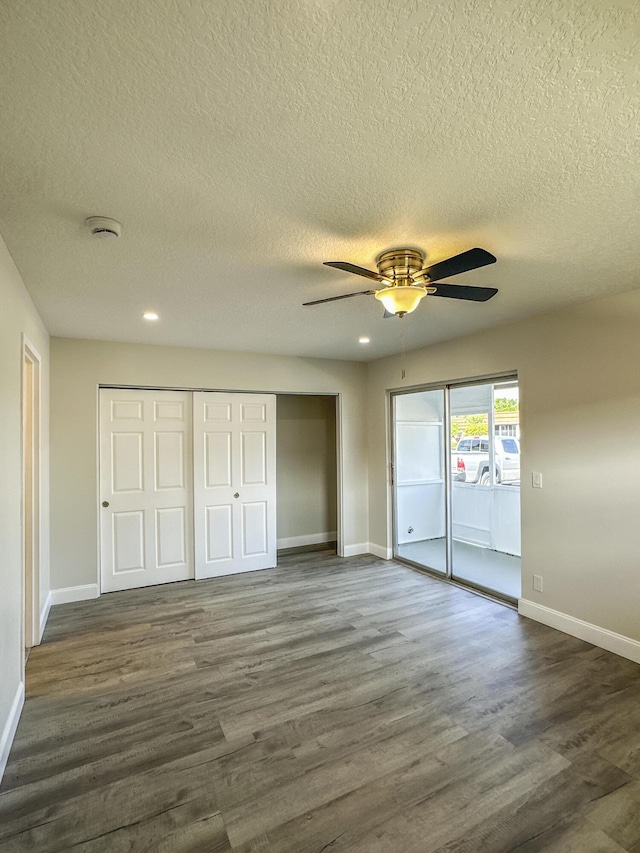 unfurnished bedroom with access to exterior, baseboards, and dark wood-type flooring