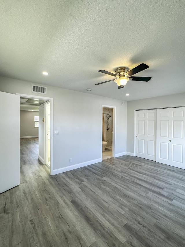 unfurnished bedroom featuring a closet, wood finished floors, visible vents, and baseboards