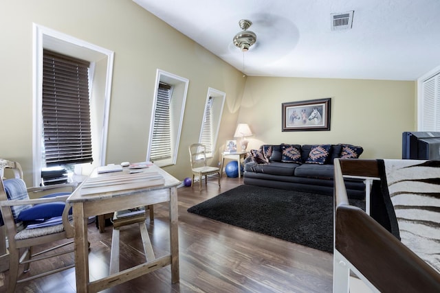 living area with ceiling fan, visible vents, vaulted ceiling, and wood finished floors