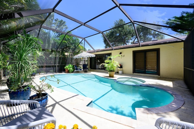 view of swimming pool featuring a patio, a lanai, and a pool with connected hot tub