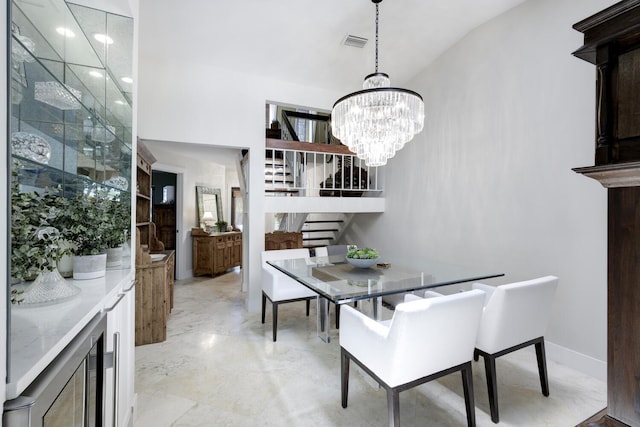 dining room with a notable chandelier, visible vents, baseboards, stairs, and marble finish floor