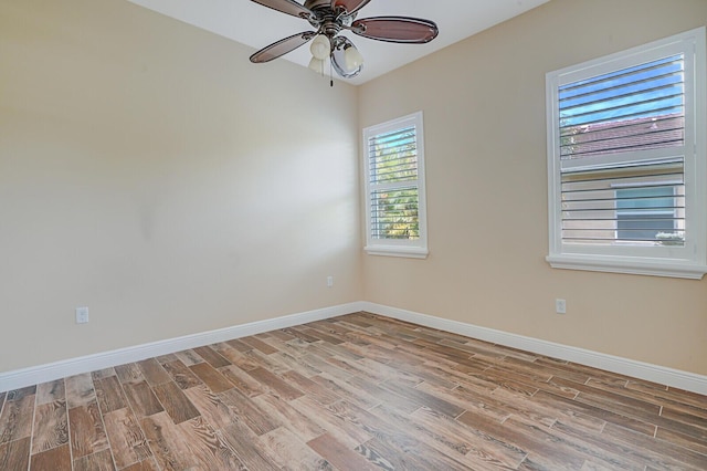 spare room with light wood-type flooring, ceiling fan, and baseboards