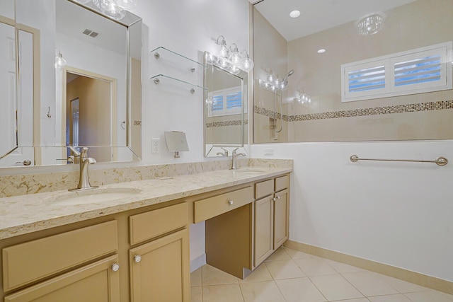 bathroom with double vanity, visible vents, walk in shower, and a sink