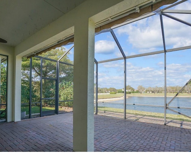 view of patio / terrace featuring a water view and a lanai