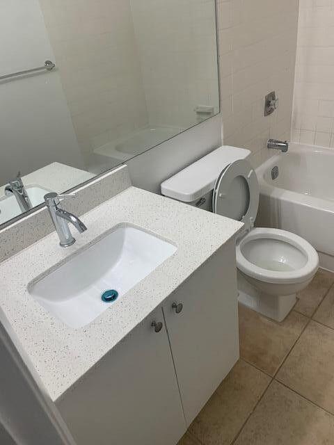 full bath featuring toilet, tile patterned floors, tub / shower combination, and vanity