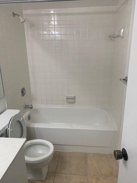 bathroom featuring toilet, shower / tub combination, vanity, and tile patterned floors