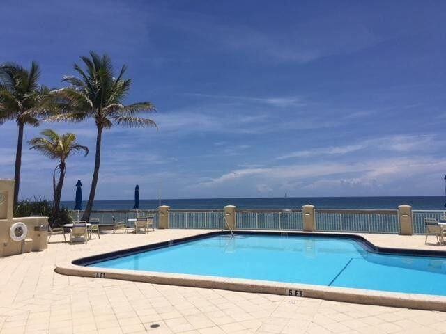 community pool with a water view and a patio