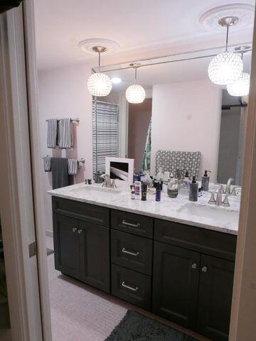 bathroom with a sink and double vanity