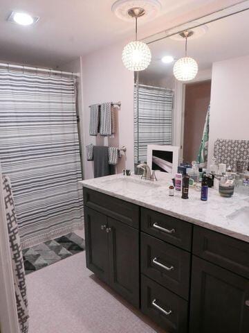 full bath with double vanity, a sink, and a shower with shower curtain