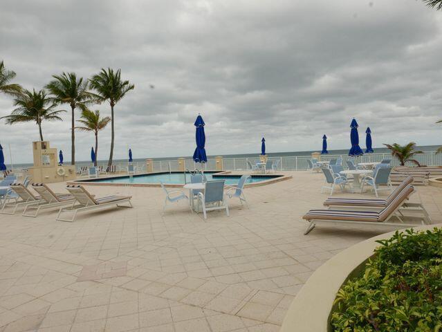 view of home's community with a patio area, a water view, and a swimming pool