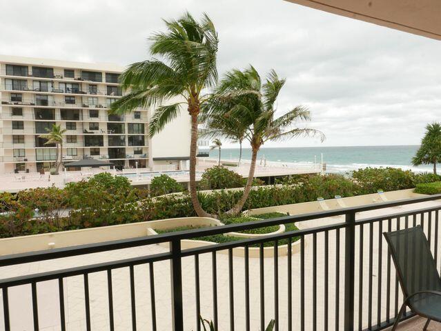 balcony featuring a beach view and a water view