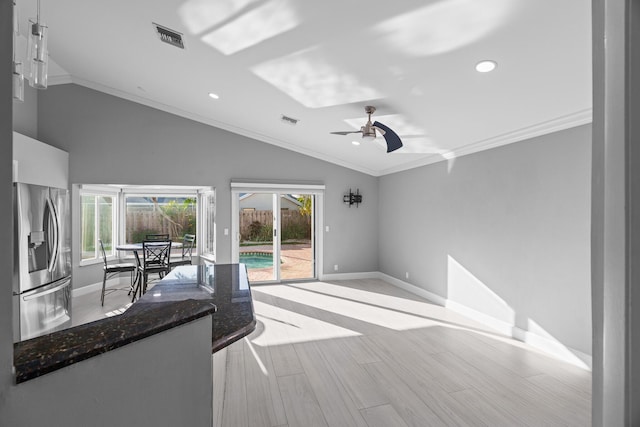 interior space featuring vaulted ceiling, plenty of natural light, visible vents, and crown molding