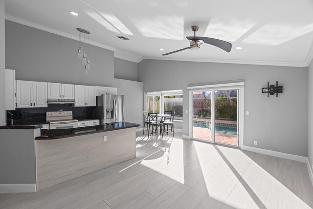 kitchen with crown molding, backsplash, appliances with stainless steel finishes, white cabinets, and under cabinet range hood