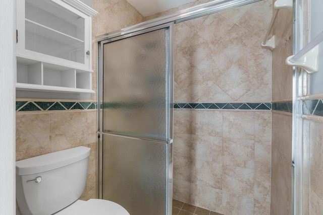 bathroom with tiled shower, tile walls, and toilet