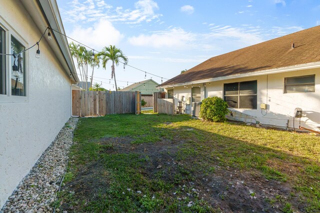 view of yard with central AC unit, fence, and a gate