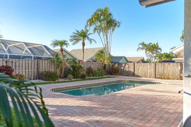 view of swimming pool with a lanai, a patio area, a fenced backyard, and a fenced in pool