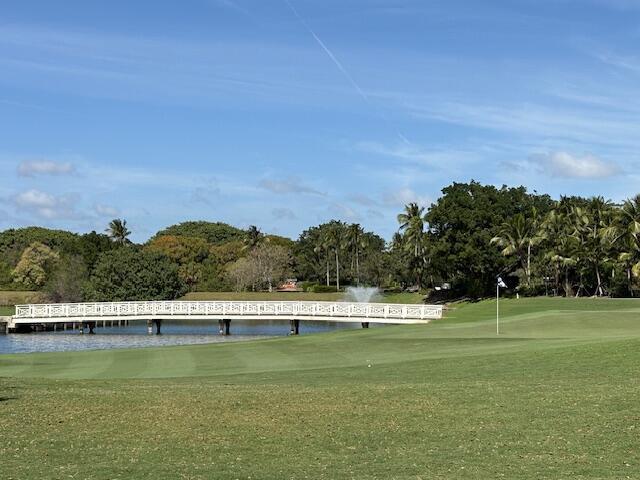 view of community featuring a water view, golf course view, and a lawn