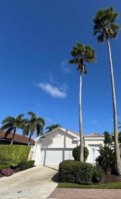 view of front of house with a garage, concrete driveway, and stucco siding