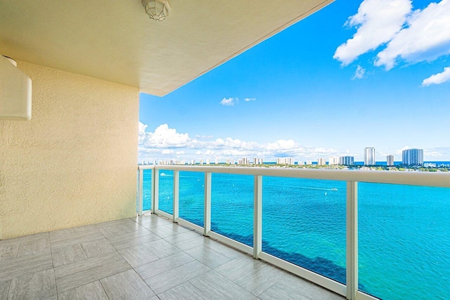 balcony featuring a water view and a city view