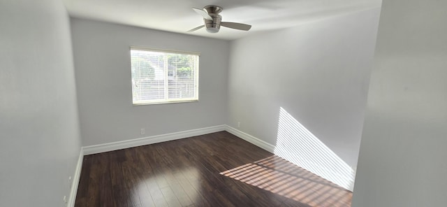 unfurnished room with dark wood-style flooring, a ceiling fan, and baseboards