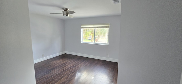 empty room with dark wood-style flooring, visible vents, ceiling fan, and baseboards