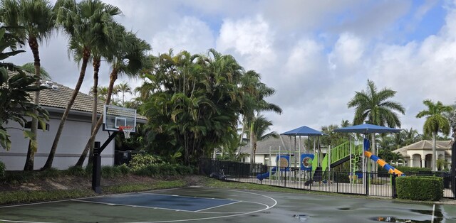 view of basketball court with playground community, fence, and community basketball court