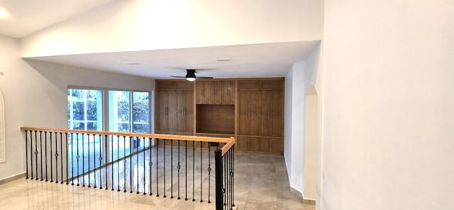 hallway with arched walkways and an upstairs landing