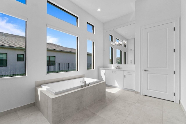 bathroom with a healthy amount of sunlight, a garden tub, vanity, and tile patterned floors