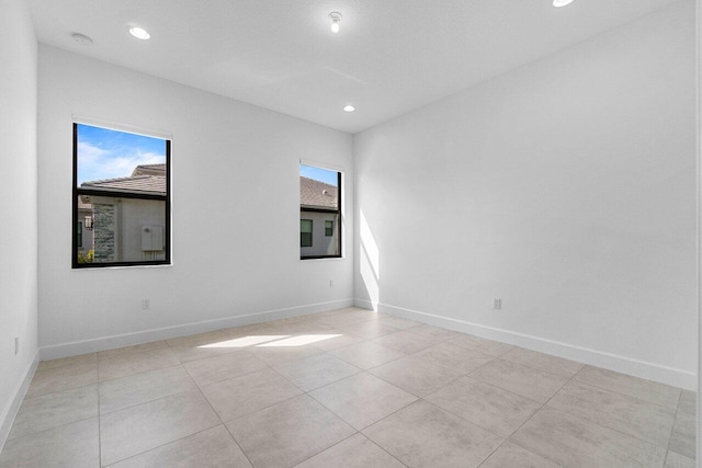 empty room with light tile patterned floors, recessed lighting, and baseboards