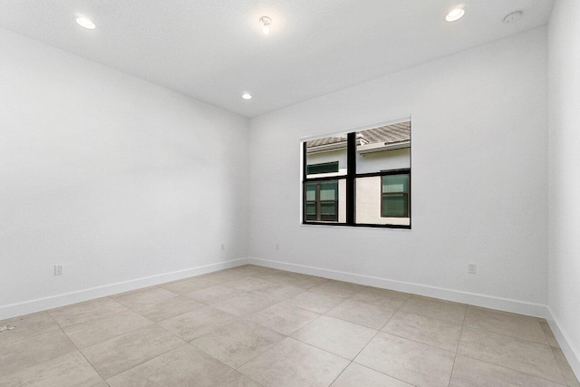 unfurnished room with recessed lighting and baseboards