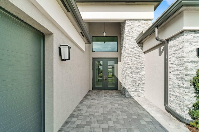 view of exterior entry with french doors and stucco siding