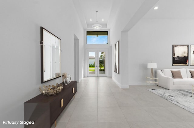 foyer entrance with light tile patterned floors, recessed lighting, a towering ceiling, baseboards, and french doors