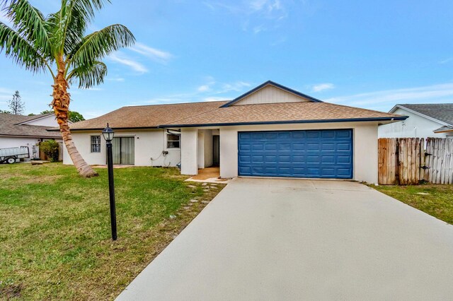 single story home featuring a shingled roof, a front yard, driveway, and stucco siding