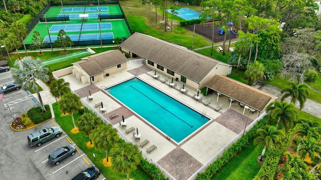 pool with a patio area and fence