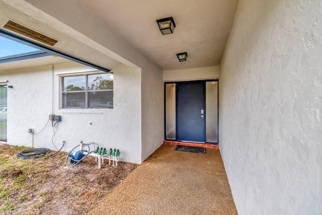 property entrance with stucco siding