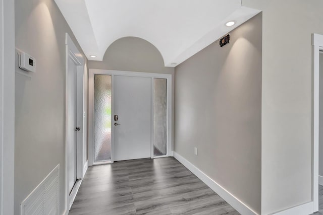 foyer entrance with baseboards, visible vents, and wood finished floors