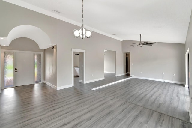 unfurnished living room featuring visible vents, wood finished floors, high vaulted ceiling, baseboards, and ceiling fan with notable chandelier