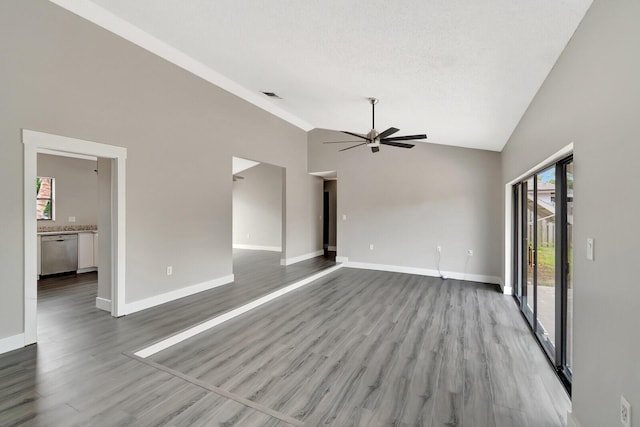 unfurnished living room featuring plenty of natural light, visible vents, ceiling fan, and wood finished floors