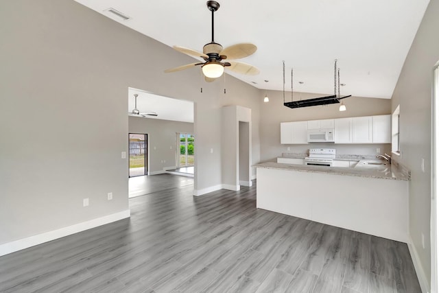 kitchen with light wood finished floors, white cabinetry, a sink, high vaulted ceiling, and white appliances