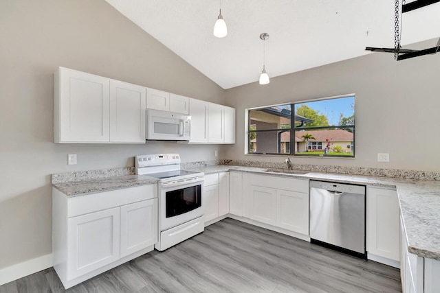 kitchen with decorative light fixtures, white cabinetry, vaulted ceiling, a sink, and white appliances