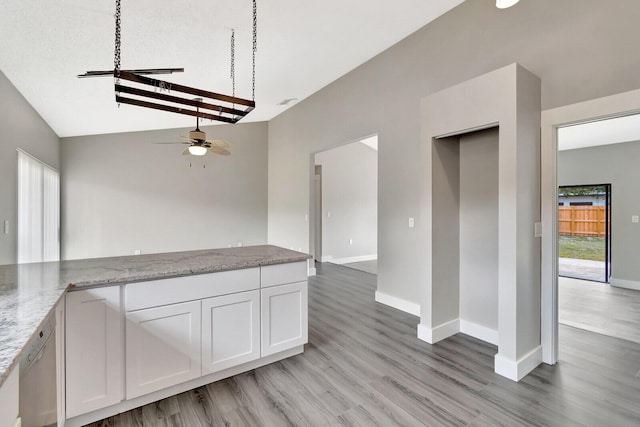 interior space with baseboards, light stone counters, light wood-style flooring, and white cabinets