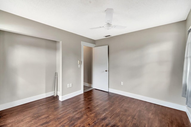 unfurnished bedroom with a ceiling fan, visible vents, baseboards, and wood finished floors