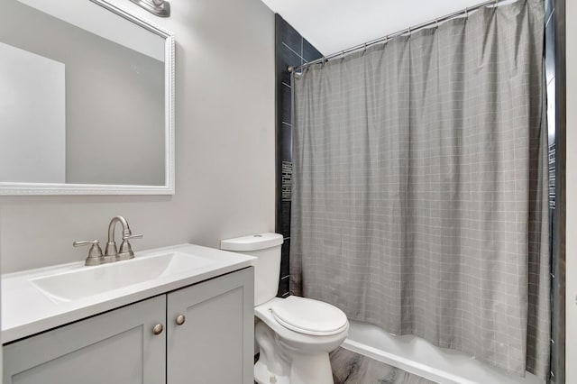 bathroom featuring toilet, shower / bath combo, wood finished floors, and vanity