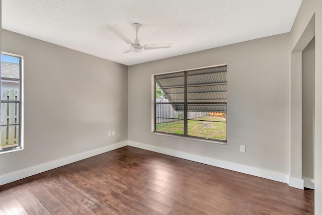 empty room with baseboards, a ceiling fan, and wood finished floors