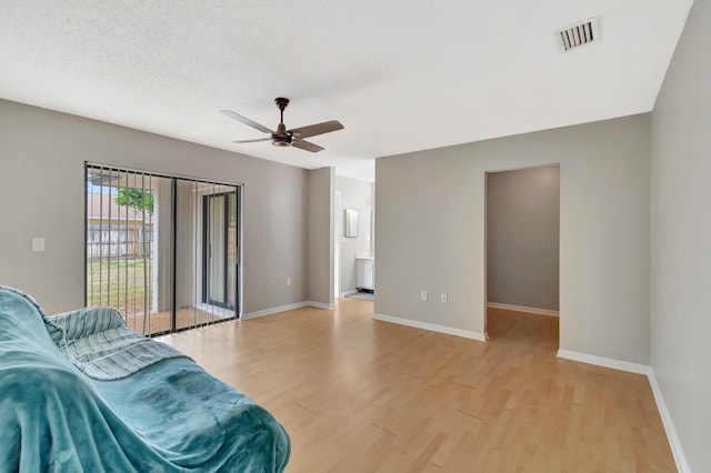 living area with visible vents, light wood-style flooring, and baseboards