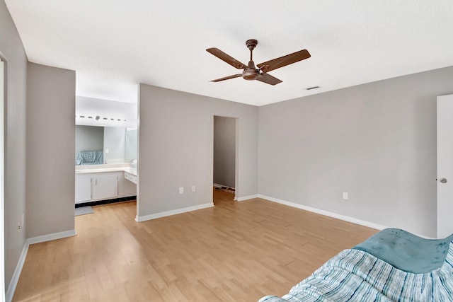 unfurnished bedroom featuring visible vents, a ceiling fan, ensuite bath, light wood-type flooring, and baseboards