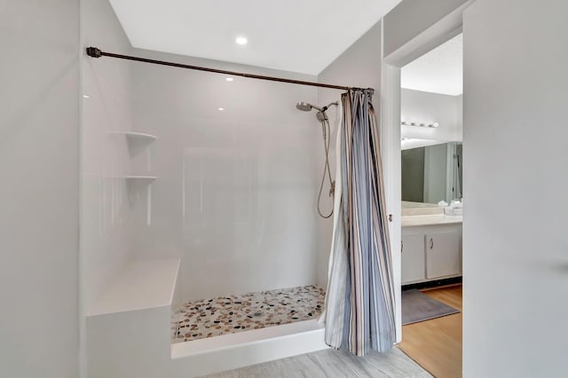 bathroom with a shower with curtain, vanity, and wood finished floors